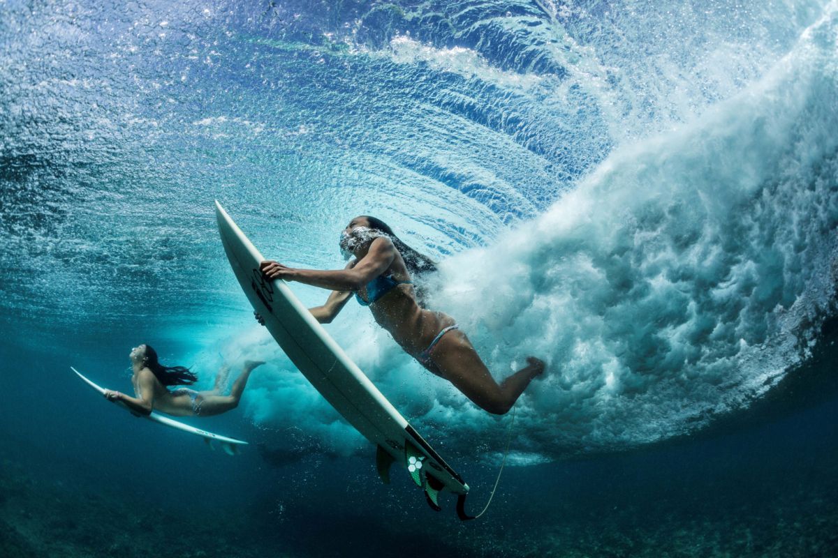 Oahu, Hawaii (©Paul Nicklen) In de Stille Oceaan voor de kust van Makaha ontwijken surfers een golf door er met hun board onder te duiken.